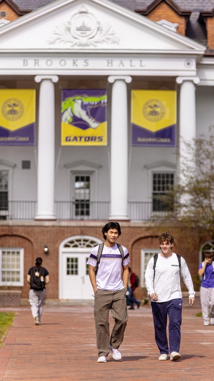 Allegheny College students walk down the brick sidewalk in front of Brooks Hall