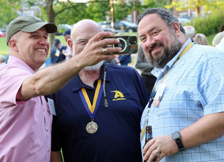 A group of three men pose for a selfie