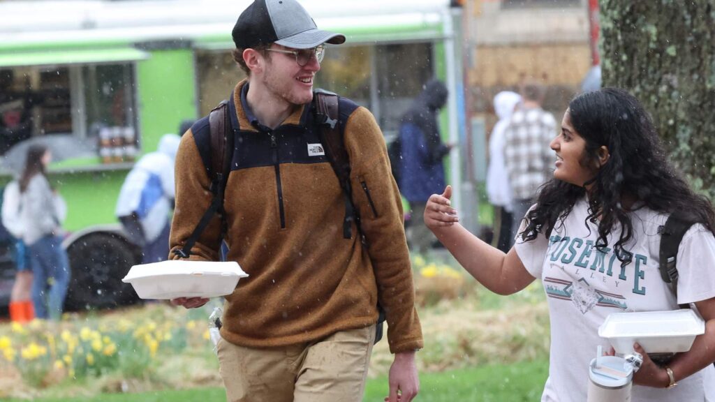 a person holding food and walking with a student