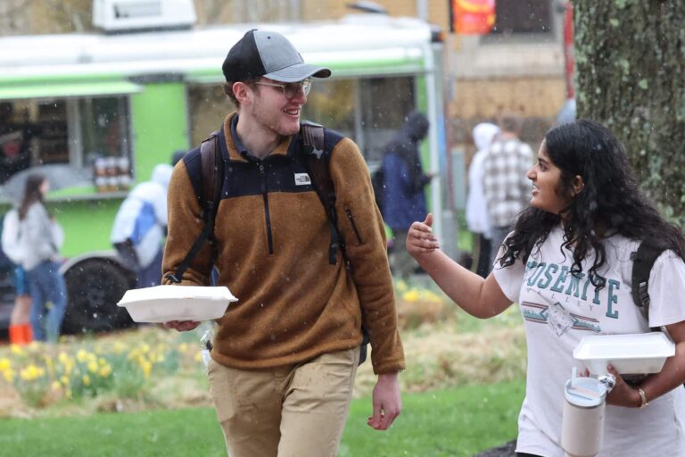 a person holding food and walking with a student