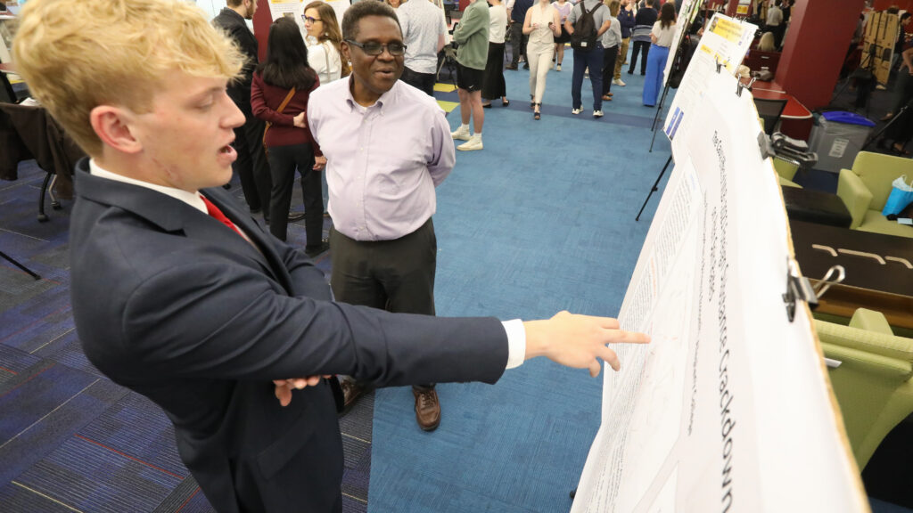 Student pointing at poster with faulty