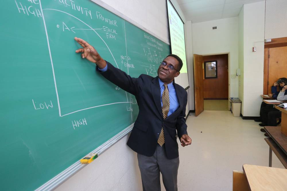 Professor pointing to a chalk board