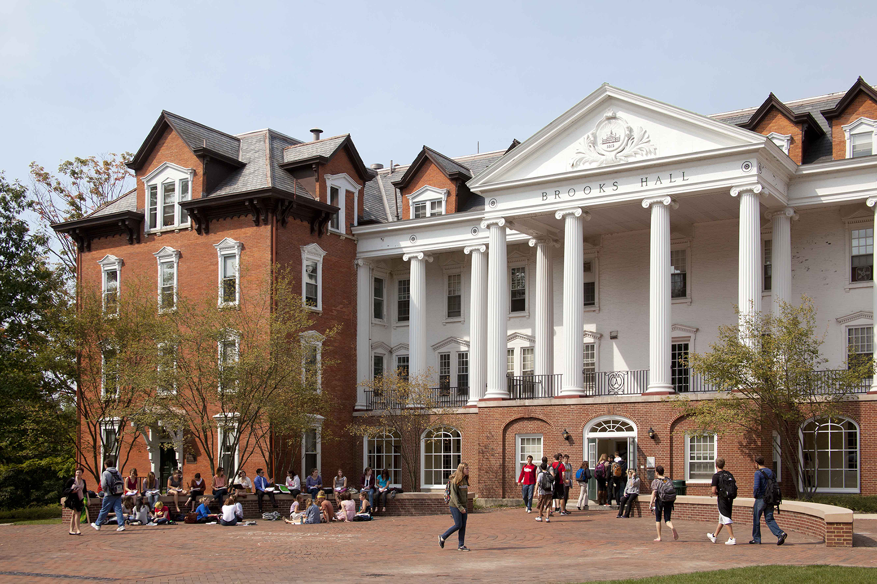 Students studying and walking in front of Brooks Hall during the day
