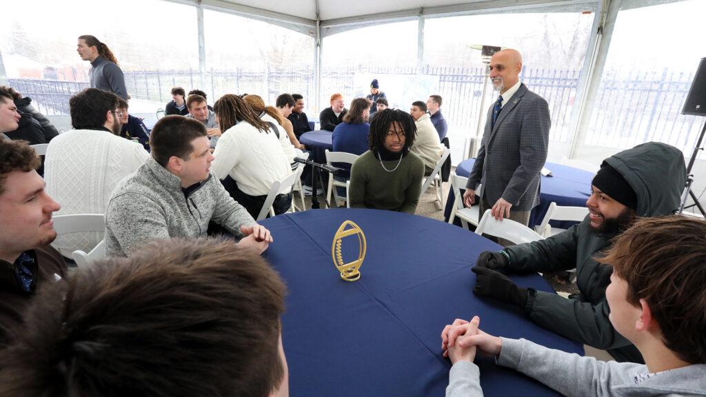 Students talking with President Cole around a table