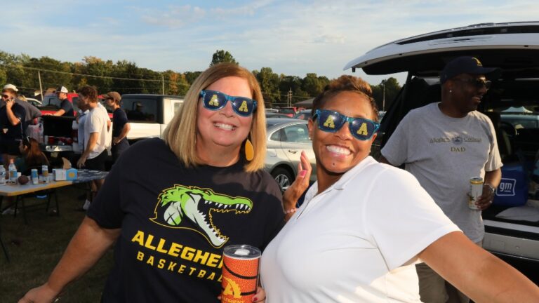 Two people wear sunglasses with an Allegheny College Athletics logo on them during the 2025 Blue and Gold Weekend