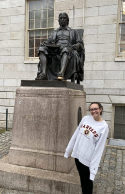 a student standing next to a statue