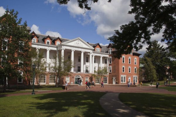 a building with columns and a lawn
