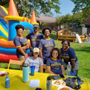 a group of students posing for a photo in front of a colorful inflatable castle