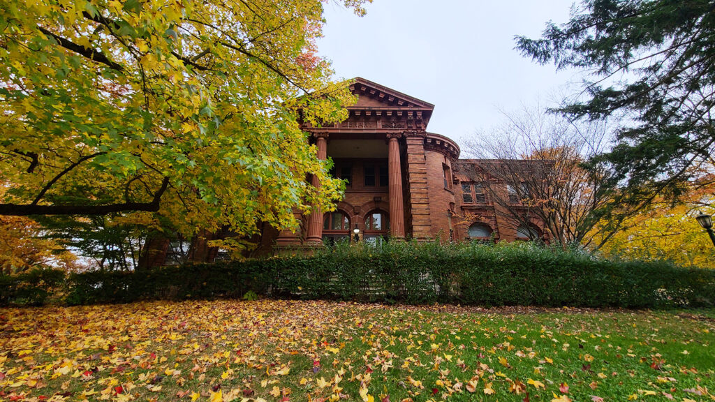 a brick building with a lawn and trees