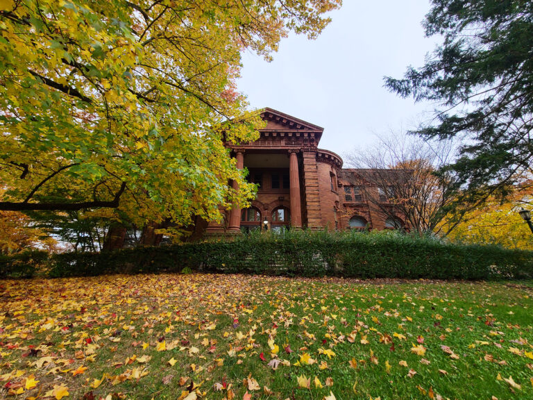 a brick building with a lawn and trees