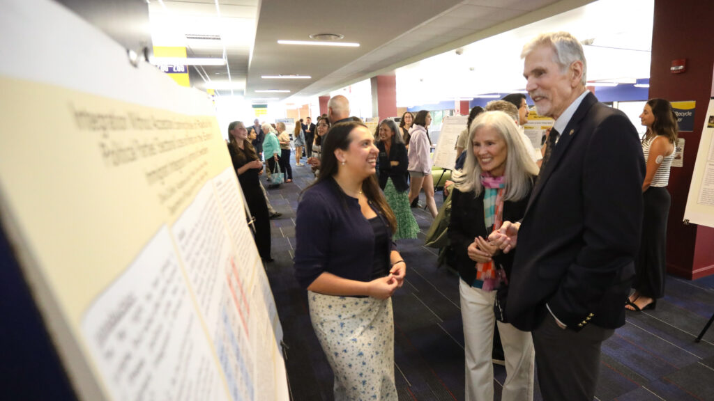 Student speaking with Richard Cook and Teresa Lahti