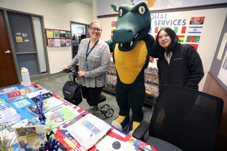 two people with gator mascot at event