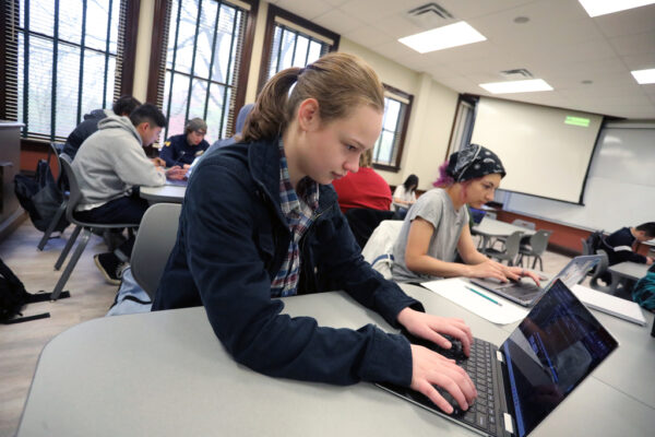 students using laptops in a classroom