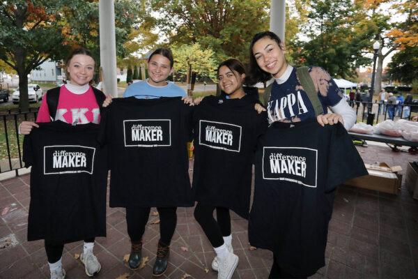 four students hold T-shirts reading 