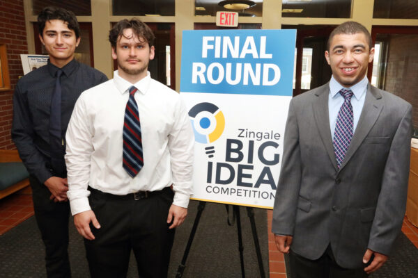 a group of students standing next to a sign