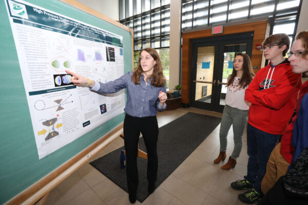 a student pointing at a research poster