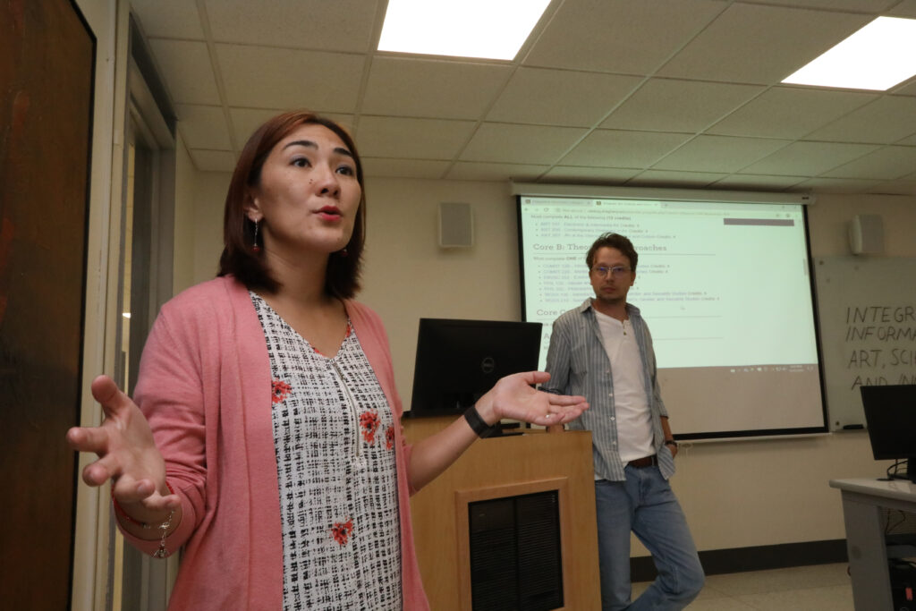 two people speaking in front of a presentation screen