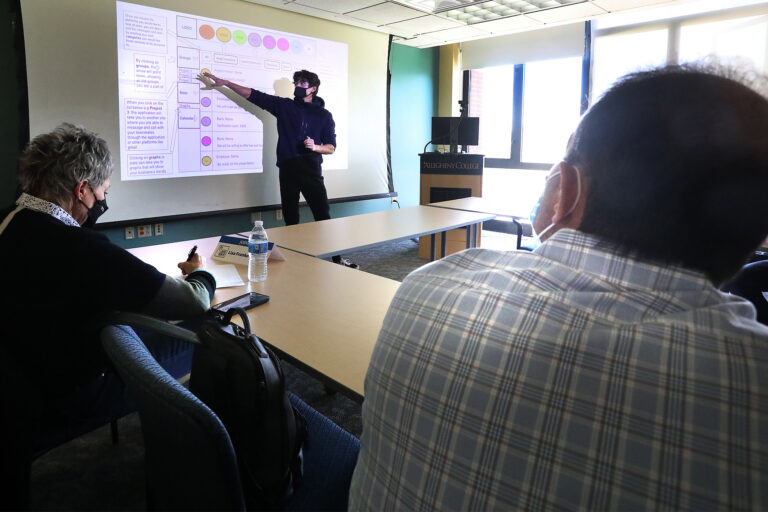 a person standing in front of a white board gesturing