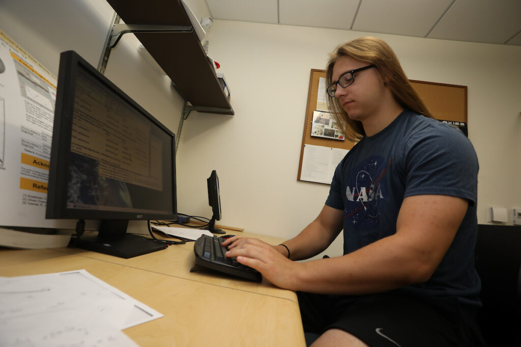 a person sitting at a desk using a computer