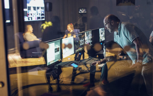 students working in a media lab in front of computers and large screens