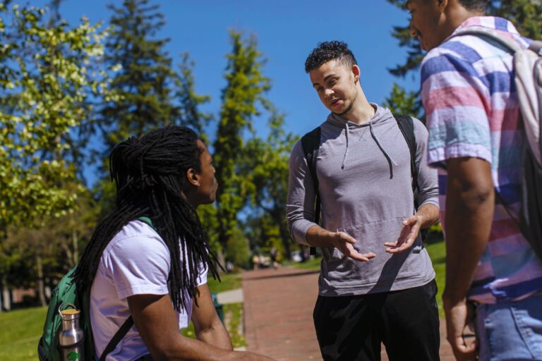 three students outdoors talking to each other