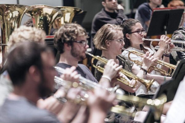 four students playing brass instruments