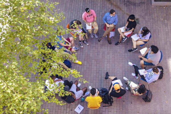 Overhead shot of students sitting in a circle outside