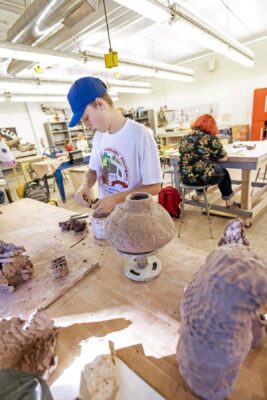 student in art studio crafting lamps