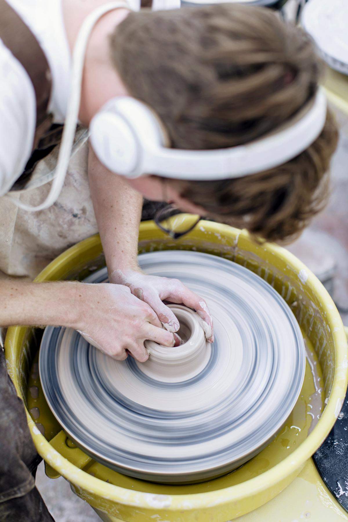 Student spinning a pottery wheel