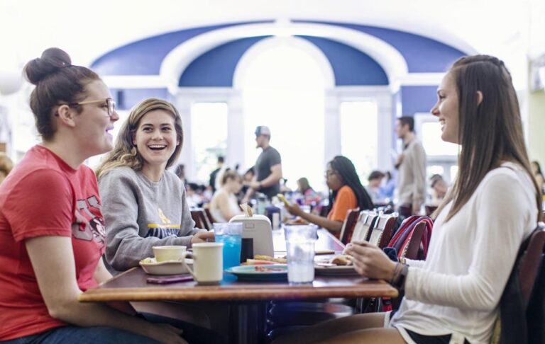 a group of students sitting at a table in a cafeteria