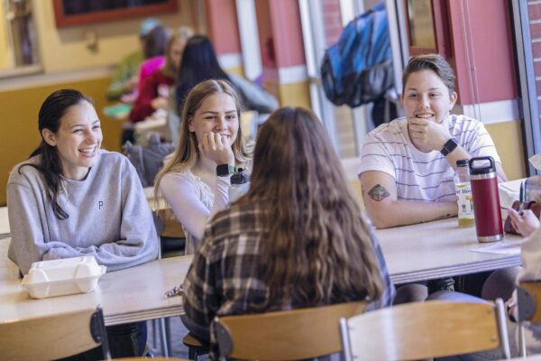 students in dining hall talking at a table