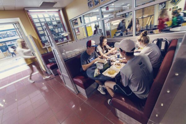 students at a booth eating food together