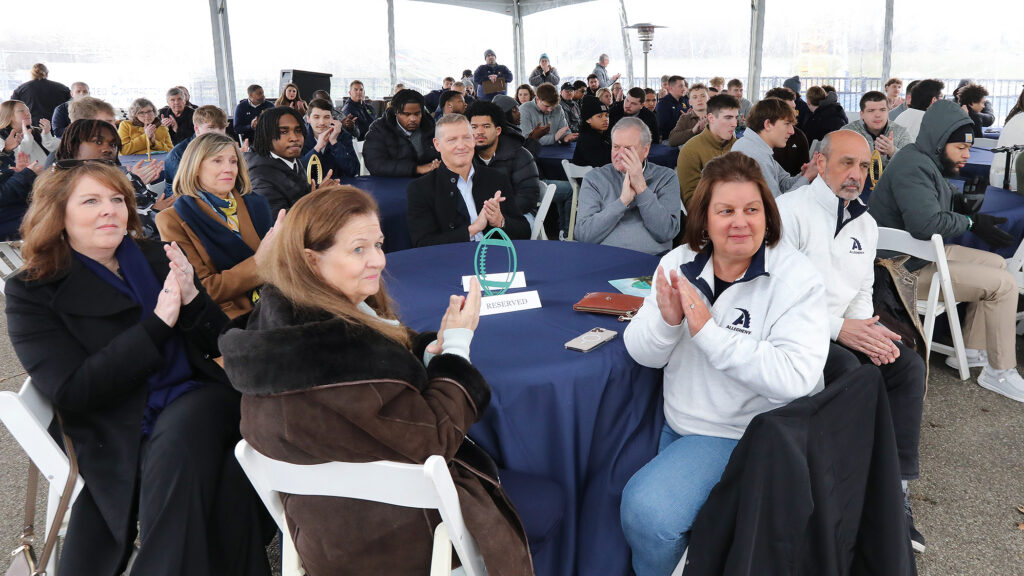 Allegheny College community sitting at tables clapping