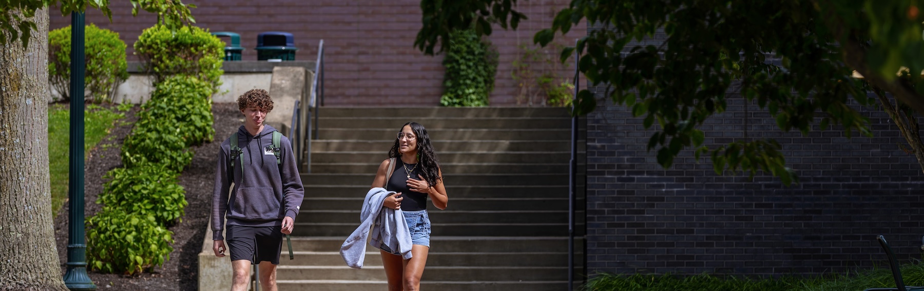 Two Allegheny College students walk down a sidewalk