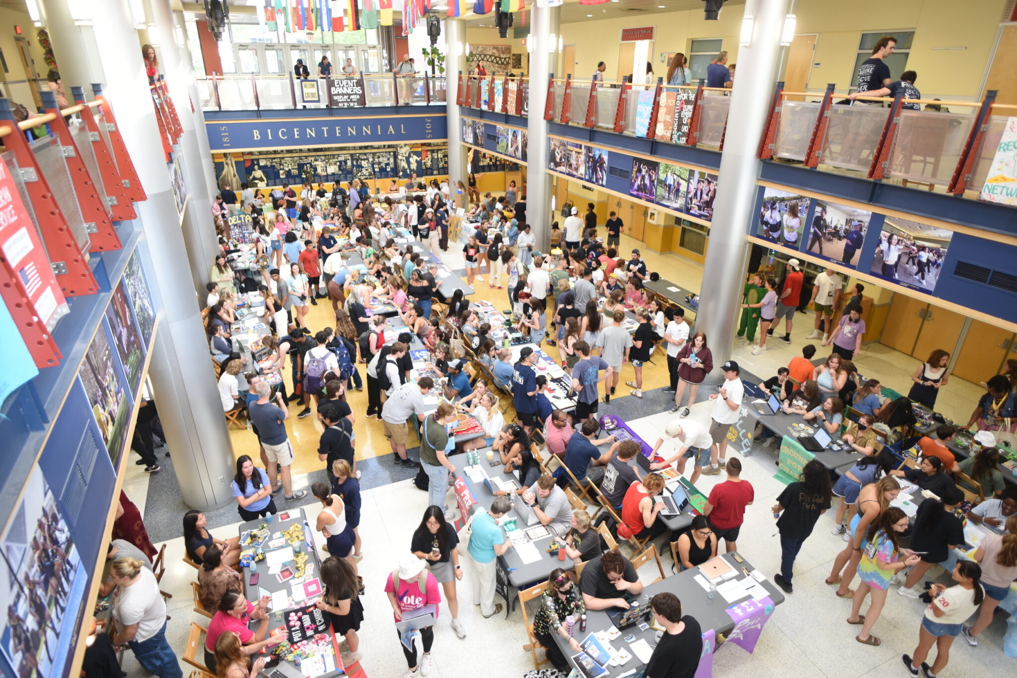 rows of tables and students in a large campus center lobby