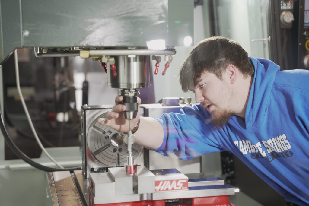 Student adjusting CNC machinery