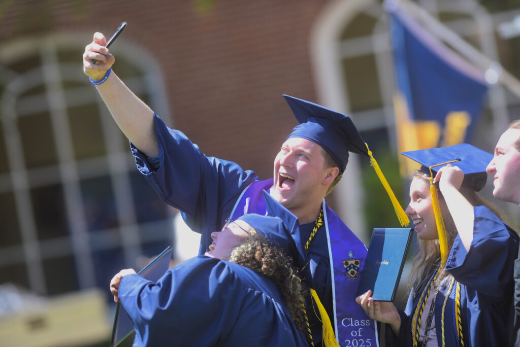 Students taking a selfie with their cap and gowns