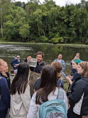 students on the edge of French Creek examining water