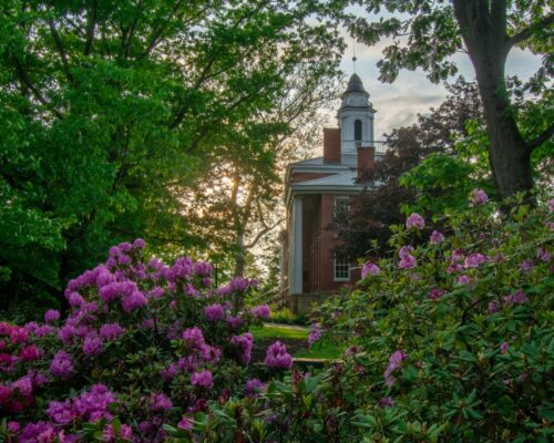Bentley Hall at Allegheny College at sunset, surrounded by trees and flowers