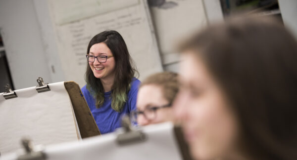 a person in glasses smiling in a classroom