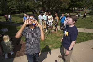 Community members gather to view the solar eclipse.