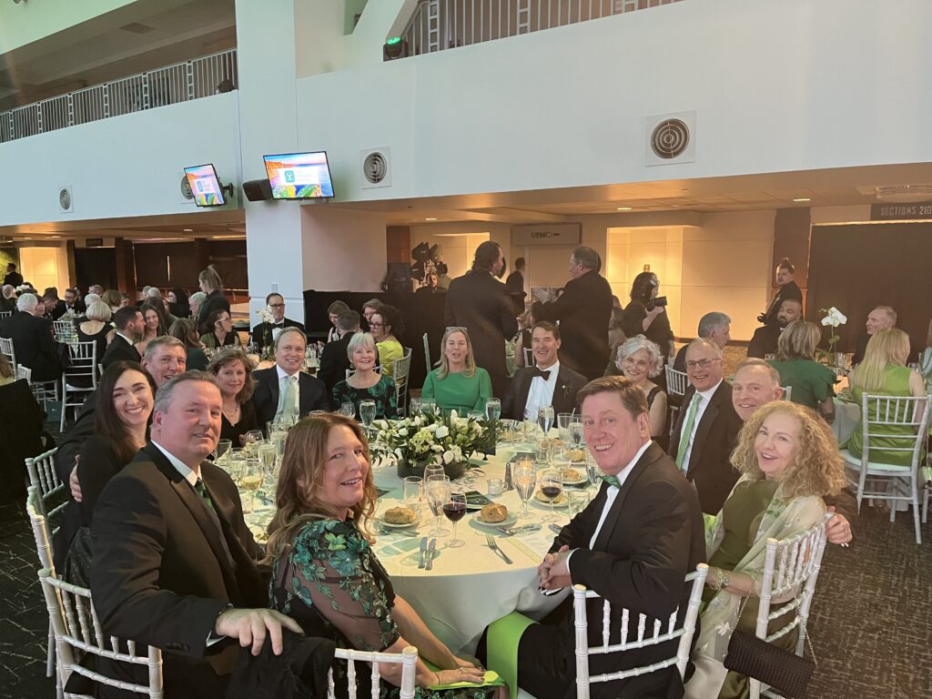 a group of people in formal dress sitting at banquet tables posing for a photo