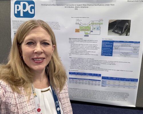 Allegheny College alum Britt McAtee stands in front of a research poster for PPG Industries