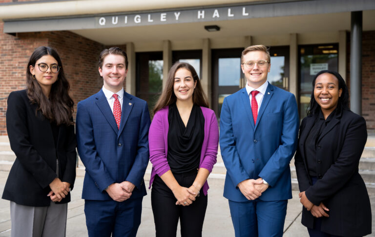 a group of students, dressed in business attire in front of a building