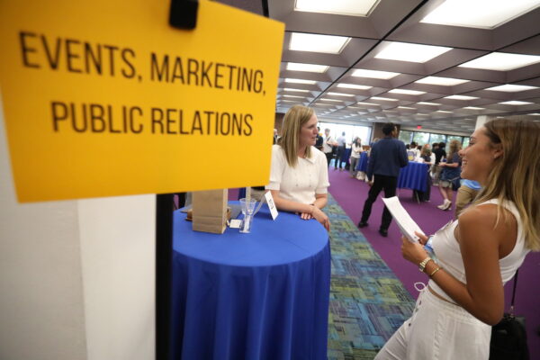 Young girl attends a Career Fair table.