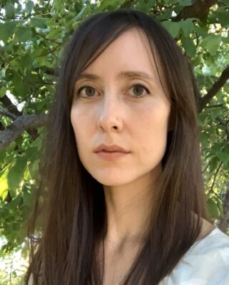 portrait of a person with long hair and a white shirt