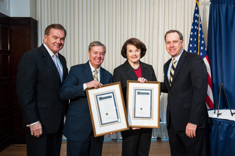 Tom Ridge, Lindsey Graham, Dianne Feinstein, and Jim Mullen posing together, the two women holding their prize certificates