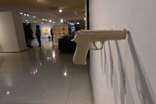 a white gun on the wall of an art museum