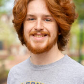 Man with thick red hair and beard wearing gray t shirt