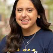 Dark haired woman wearing navy t shirt and necklaces